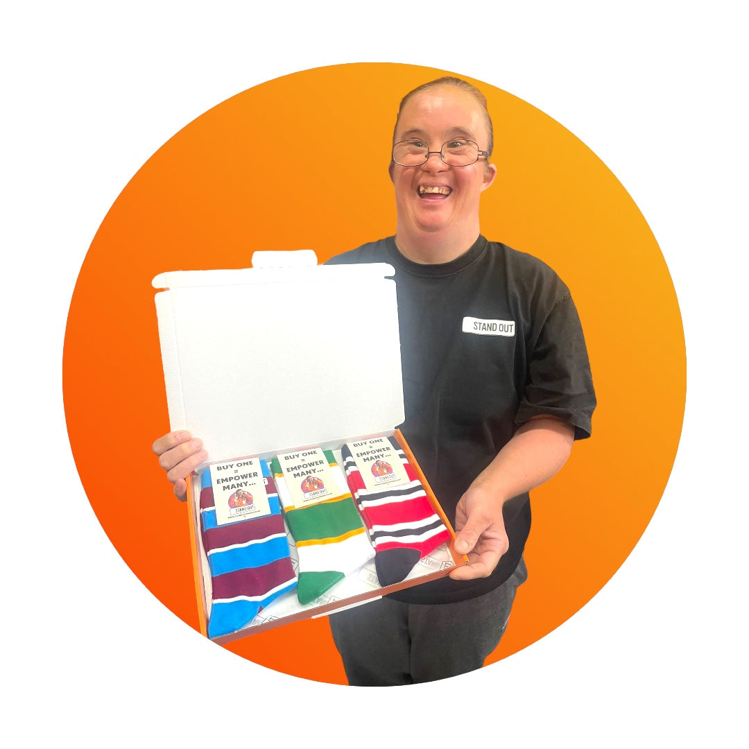 A Lady proudly holding up a box with 3 pairs of striped socks