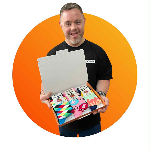 Man holding a box of colorful socks with an orange circle background