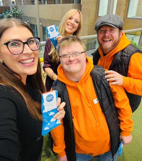 staff from stand out socks smile while stood next to staff from cloud co who are holding cloud socks