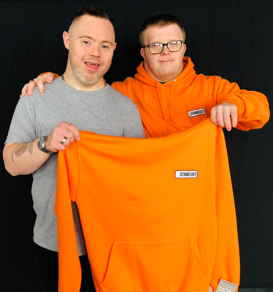 Oliver & Ross of Stand Out Socks Holding a Stand Out Hoodie and Smiling 
