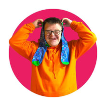 Load image into Gallery viewer, a man with glasses on smiling and holding some fish pattern socks with a pink circle frame around him
