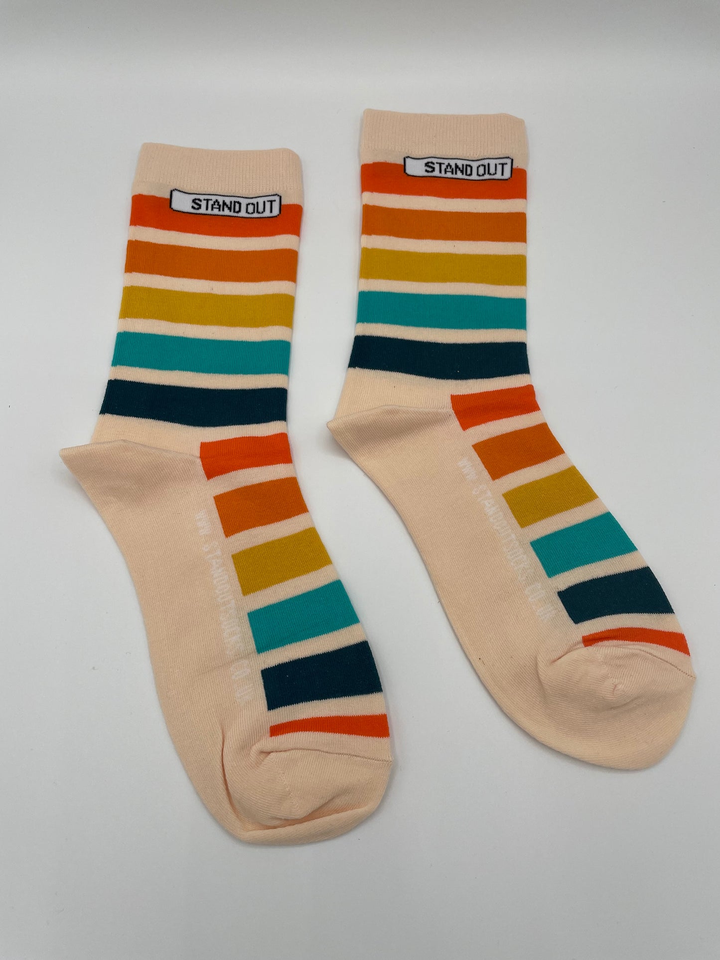 Pair of beige socks with colorful stripes on a white background