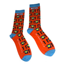 Load image into Gallery viewer, Man with Glasses on and orange jumper, Smiling and holding a pair of colourful Down Syndrome Awareness Socks
