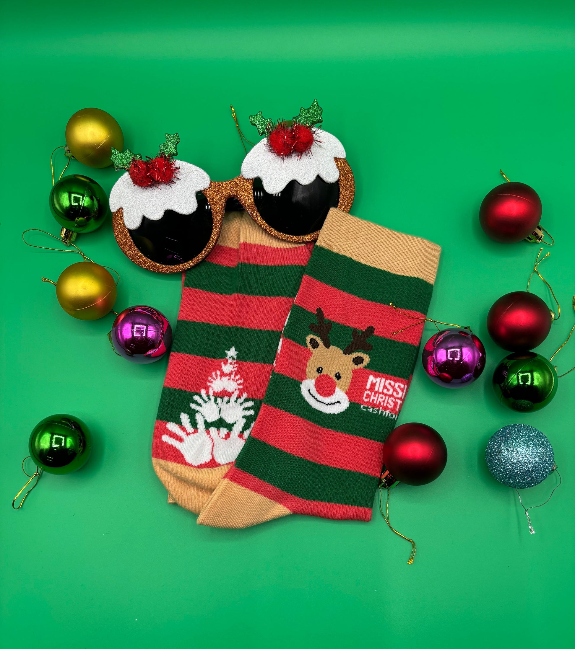 Christmas-themed socks with reindeer design and decorative ornaments on a green background