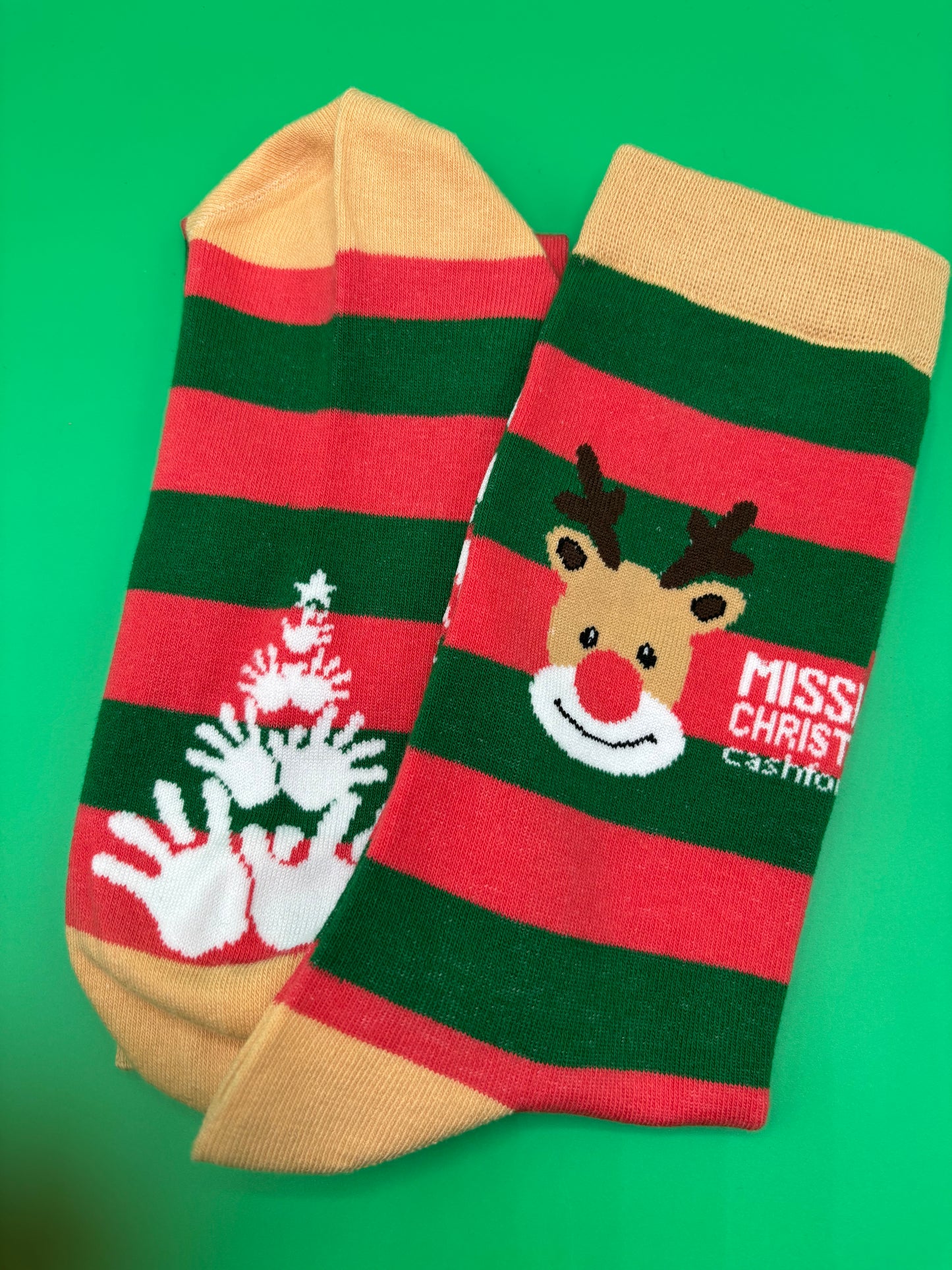 Christmas-themed socks with reindeer design on a green background