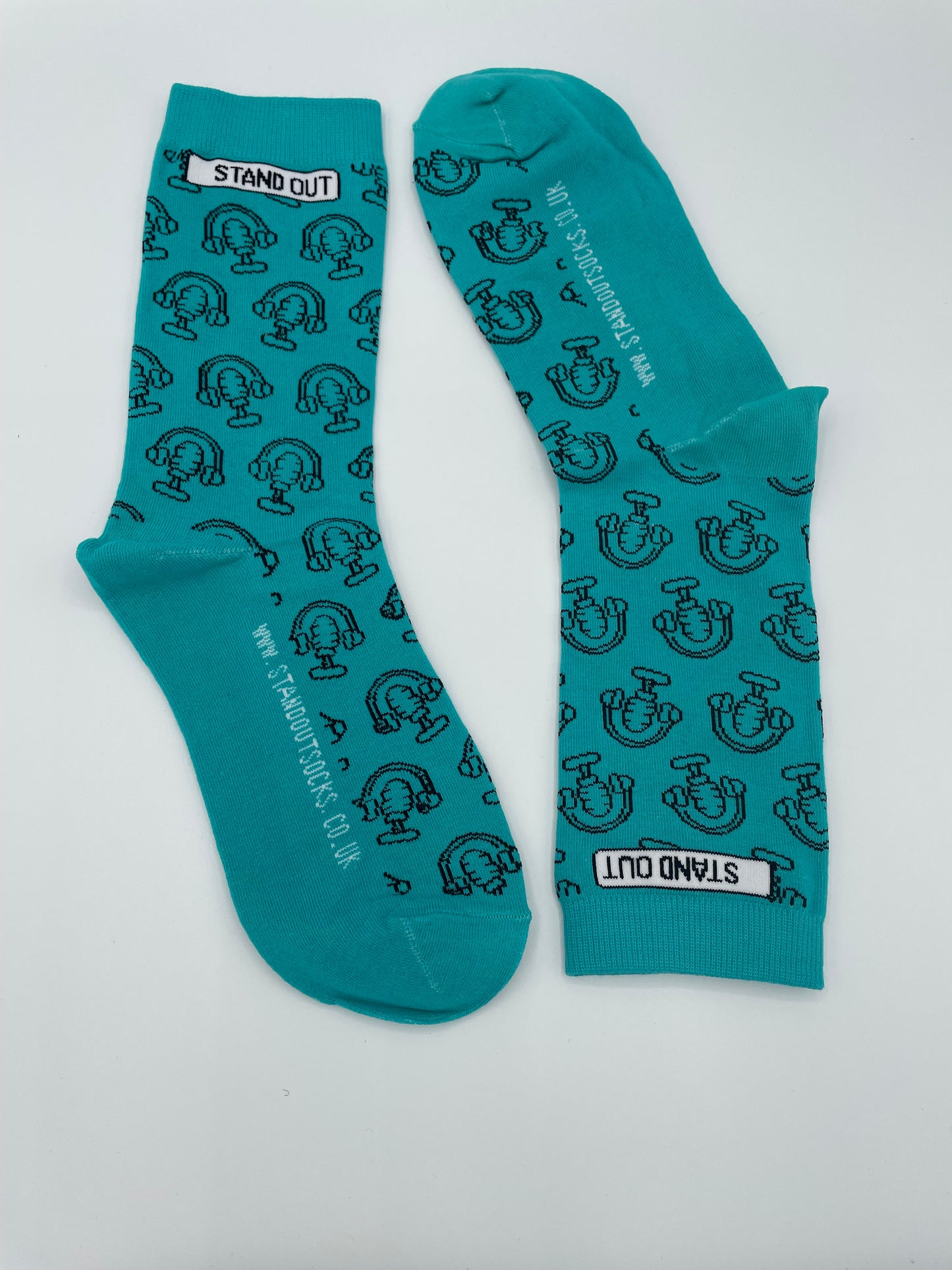 Teal socks with black pattern and 'Stand Out' branding on a white background