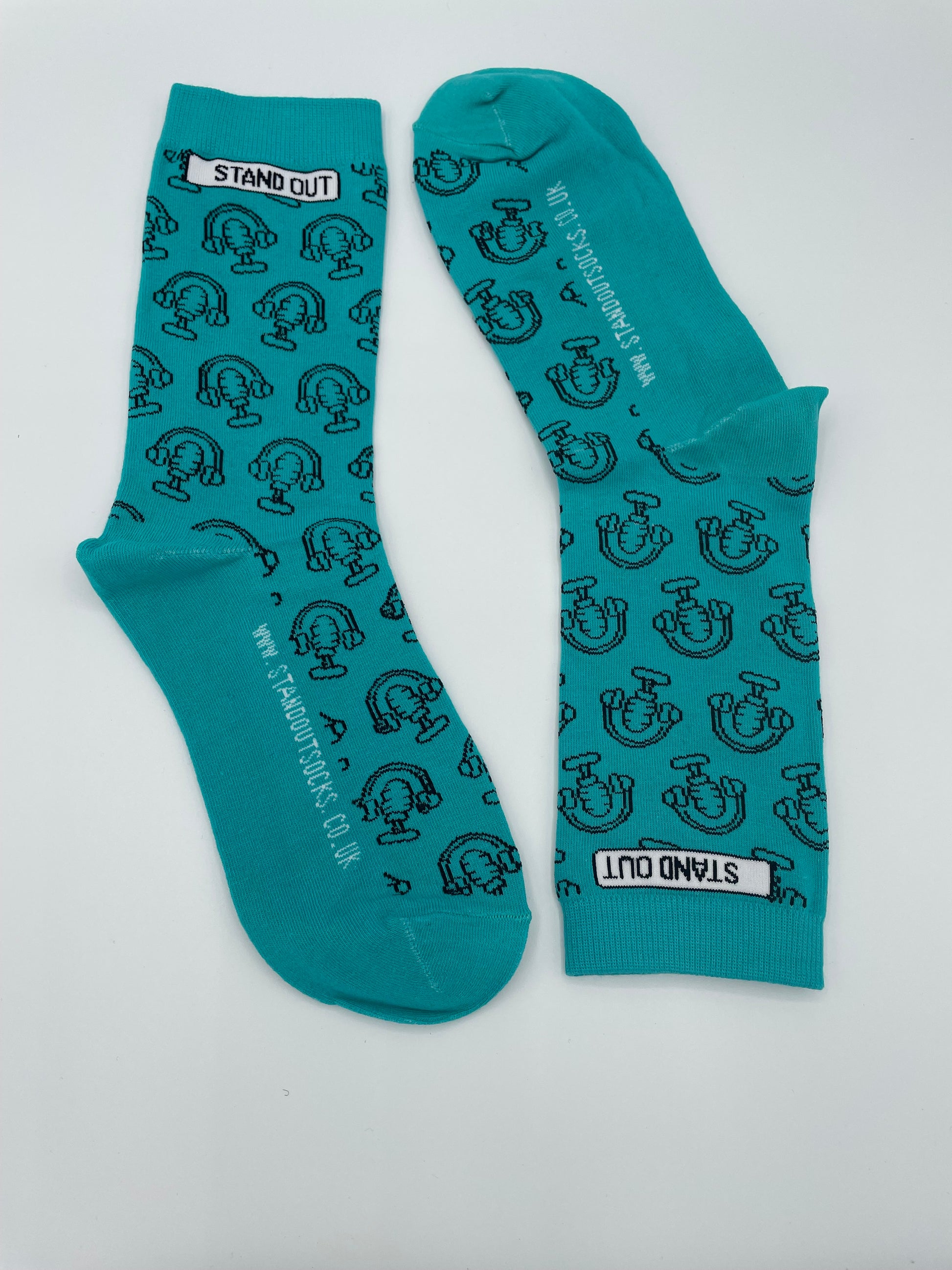 Teal socks with black pattern and 'Stand Out' branding on a white background