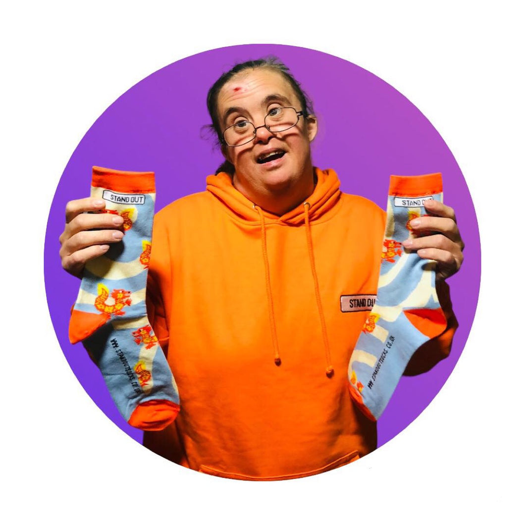 Martha From Stand Out Socks Holding a pair of The Dragon Socks 