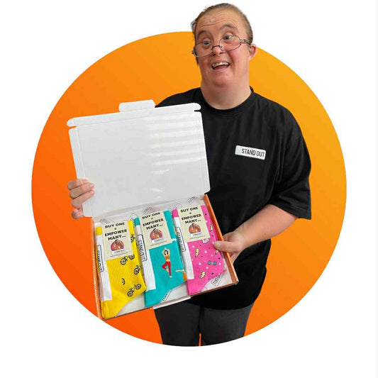 Person holding a box of colourful socks against an orange background